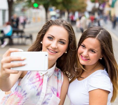 Two girls wearing braces taking a selfie