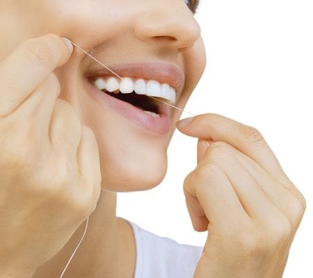 Woman and teeth floss - Young caucasian woman flossing her teeth (close up woman smile)