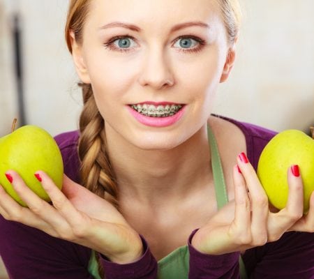 Woman young female long haired holding two big green yellow apple fruits. Healthy eating, vegetarian food, dieting and people concept.