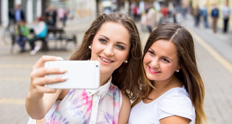 Two girls wearing braces taking a selfie