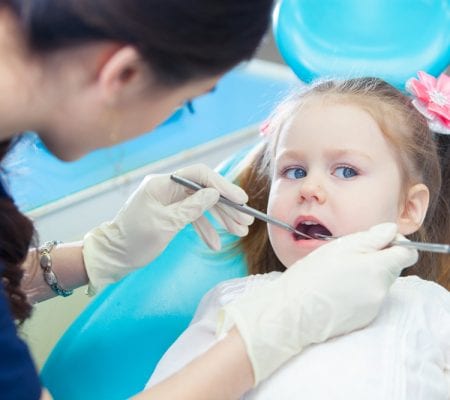 Little girl sits in the dentist's office