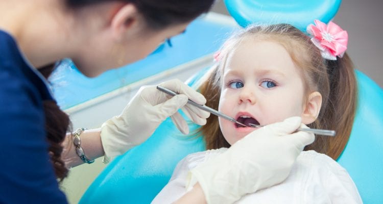 Little girl sits in the dentist's office