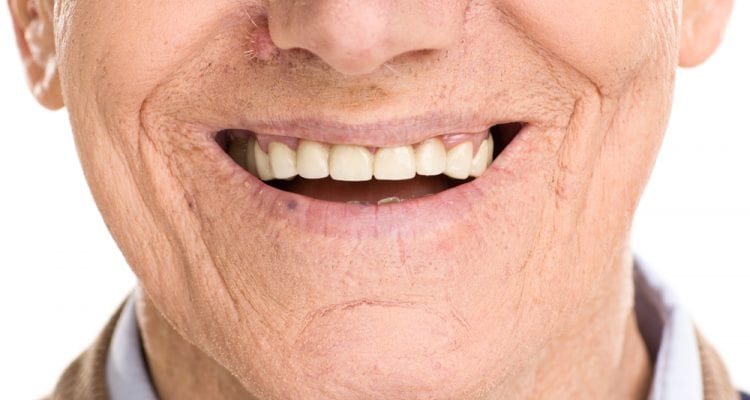 Close-up on cheerful senior man smiling isolated on white background