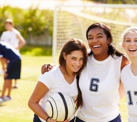 Members of Female High School Soccer Team smiling.